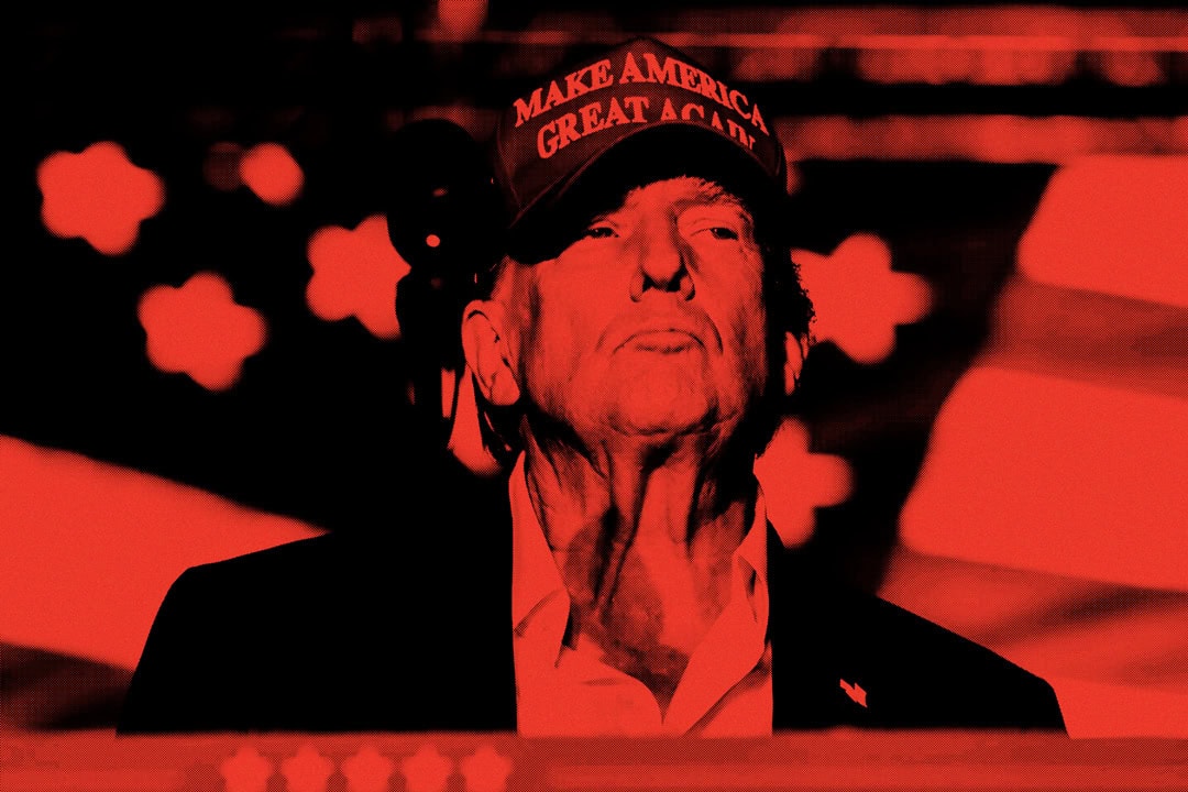 Donald Trump wearing a "Make America Great Again" hat while standing against a red background with a blurred American flag. The focus is on the man’s facial expression and neck pussy, showcasing a serious demeanor.